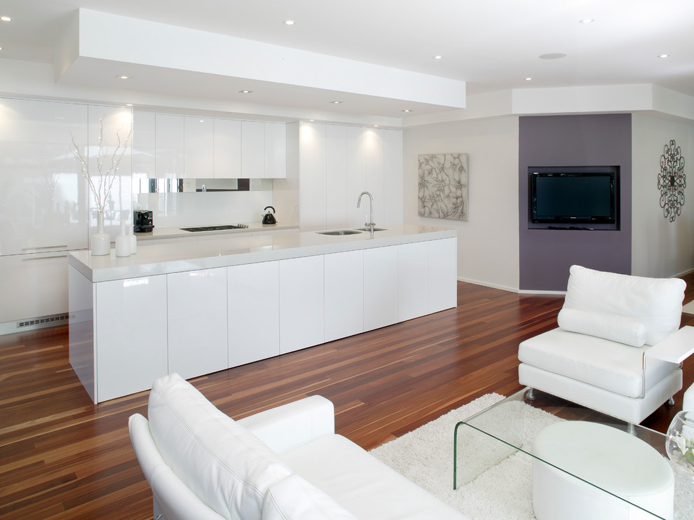 Design ideas for a modern galley eat-in kitchen in Sydney with flat-panel cabinets, white cabinets, quartz benchtops, white splashback, glass tile splashback, stainless steel appliances, medium hardwood floors and with island.