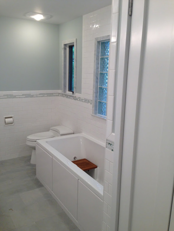Drop-in bathtub - mid-sized transitional 3/4 blue tile, gray tile, white tile and subway tile gray floor drop-in bathtub idea in Chicago with furniture-like cabinets, white cabinets, white walls, an integrated sink and glass countertops
