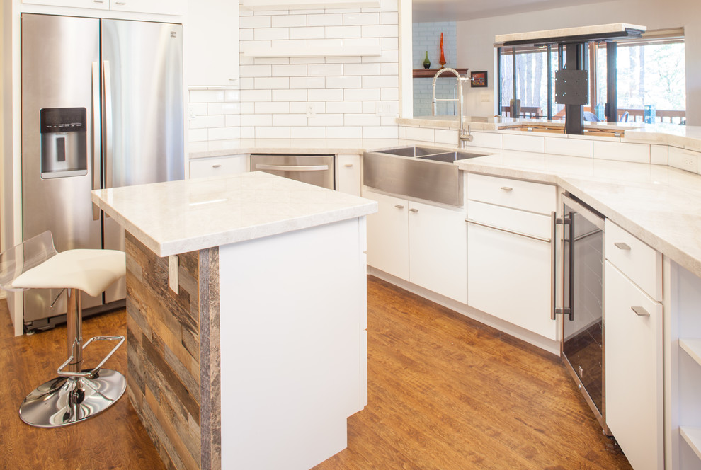 Photo of a mid-sized midcentury u-shaped eat-in kitchen in Phoenix with an undermount sink, flat-panel cabinets, white cabinets, quartzite benchtops, white splashback, subway tile splashback, stainless steel appliances, light hardwood floors, with island, brown floor and white benchtop.