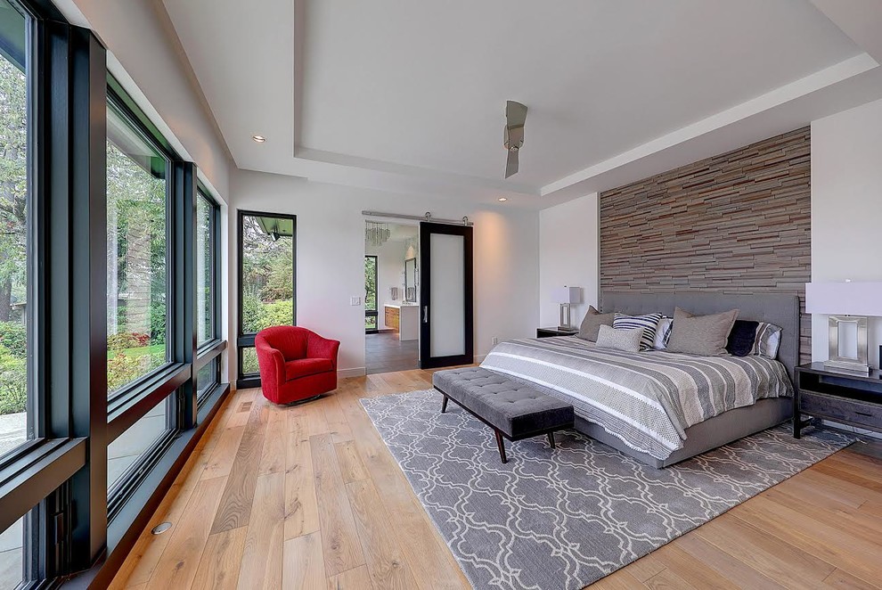 Photo of a large contemporary master bedroom in Portland with white walls, light hardwood floors and no fireplace.
