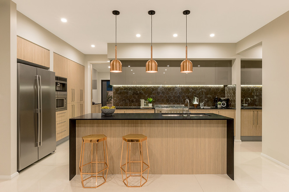 This is an example of a large contemporary u-shaped open plan kitchen in Newcastle - Maitland with a double-bowl sink, flat-panel cabinets, light wood cabinets, black splashback, ceramic splashback, stainless steel appliances and with island.