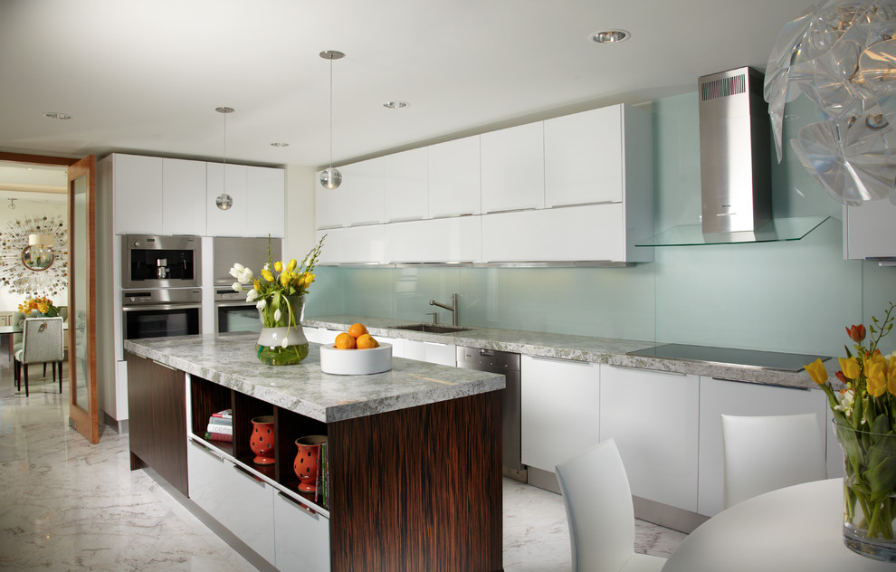 This is an example of a large contemporary l-shaped eat-in kitchen in Miami with flat-panel cabinets, glass sheet splashback, white cabinets, stainless steel appliances, an undermount sink, marble benchtops, green splashback, marble floors, with island and multi-coloured floor.