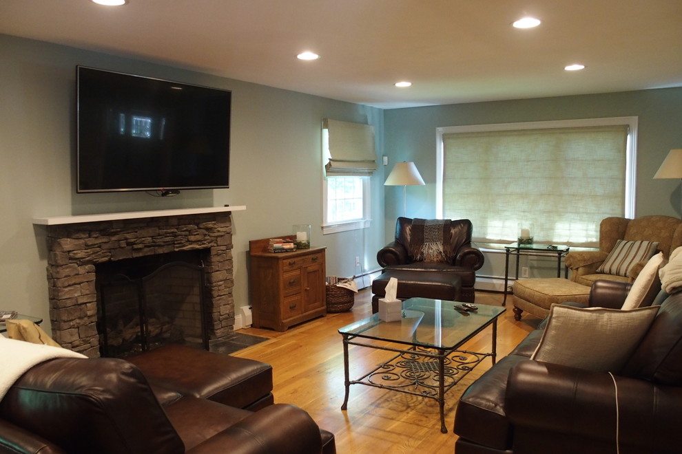 Photo of a mid-sized transitional enclosed family room in Bridgeport with grey walls, a standard fireplace, a stone fireplace surround, a wall-mounted tv, light hardwood floors and brown floor.