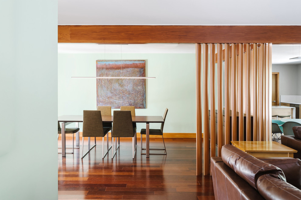 Inspiration for a midcentury dining room in Austin with green walls and medium hardwood floors.