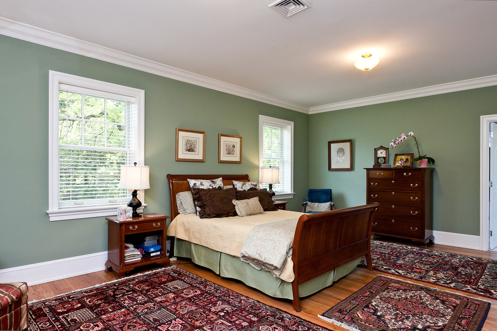 Design ideas for a mid-sized transitional master bedroom in Philadelphia with green walls and medium hardwood floors.