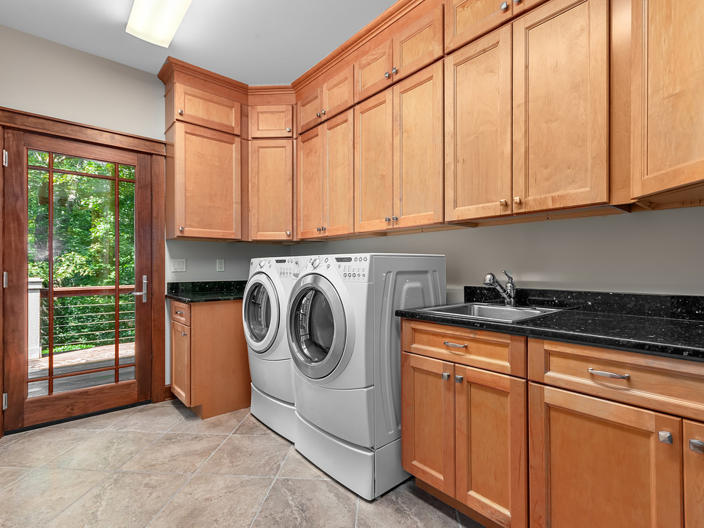 Example of a mid-sized arts and crafts l-shaped porcelain tile and beige floor dedicated laundry room design with a drop-in sink, recessed-panel cabinets, light wood cabinets, granite countertops, beige walls, a side-by-side washer/dryer and black countertops