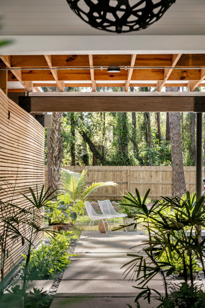 Geräumiger Moderner Garten im Sommer, hinter dem Haus mit Gehweg, direkter Sonneneinstrahlung, Flusssteinen und Holzzaun in Tampa