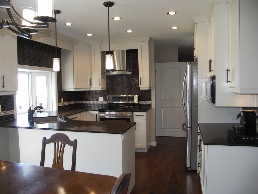 Kitchen - transitional u-shaped medium tone wood floor kitchen idea in Edmonton with an undermount sink, shaker cabinets, white cabinets, granite countertops, black backsplash and stainless steel appliances
