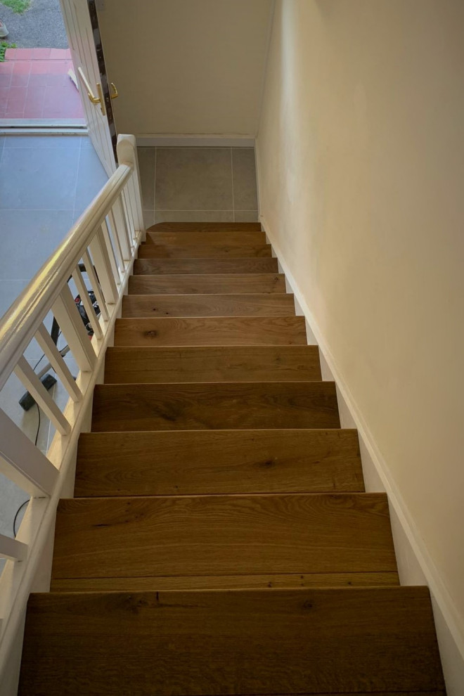 Inspiration for a large traditional wood staircase in Hertfordshire with wood risers and wood railing.