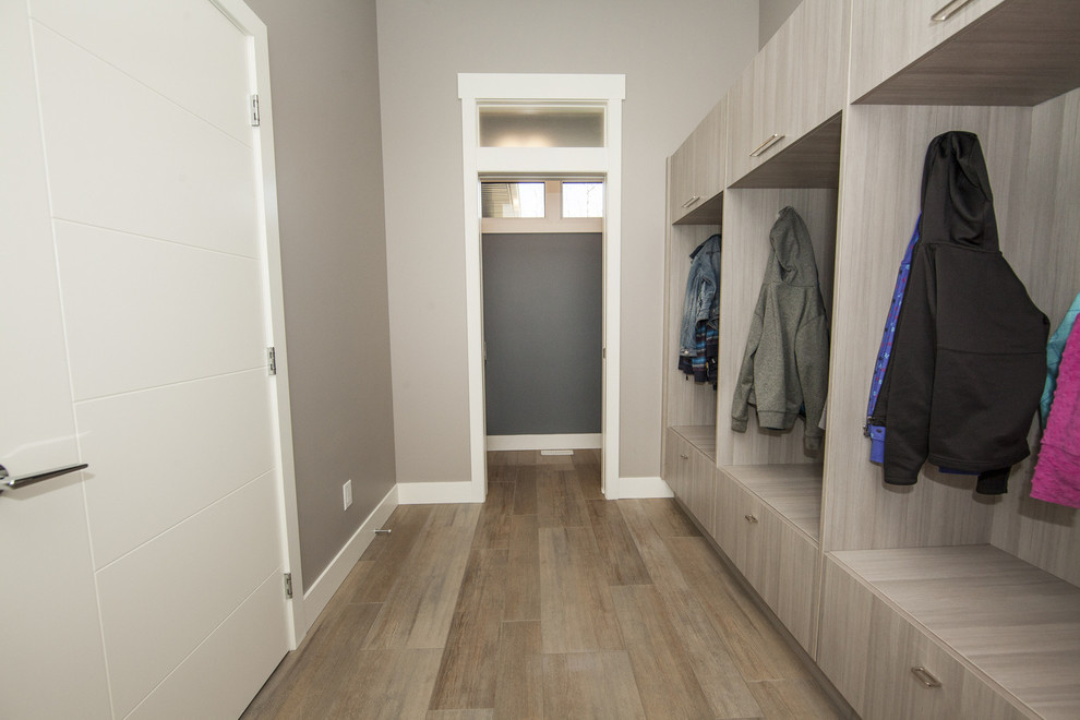 Design ideas for a large contemporary mudroom in Edmonton with grey walls and light hardwood floors.