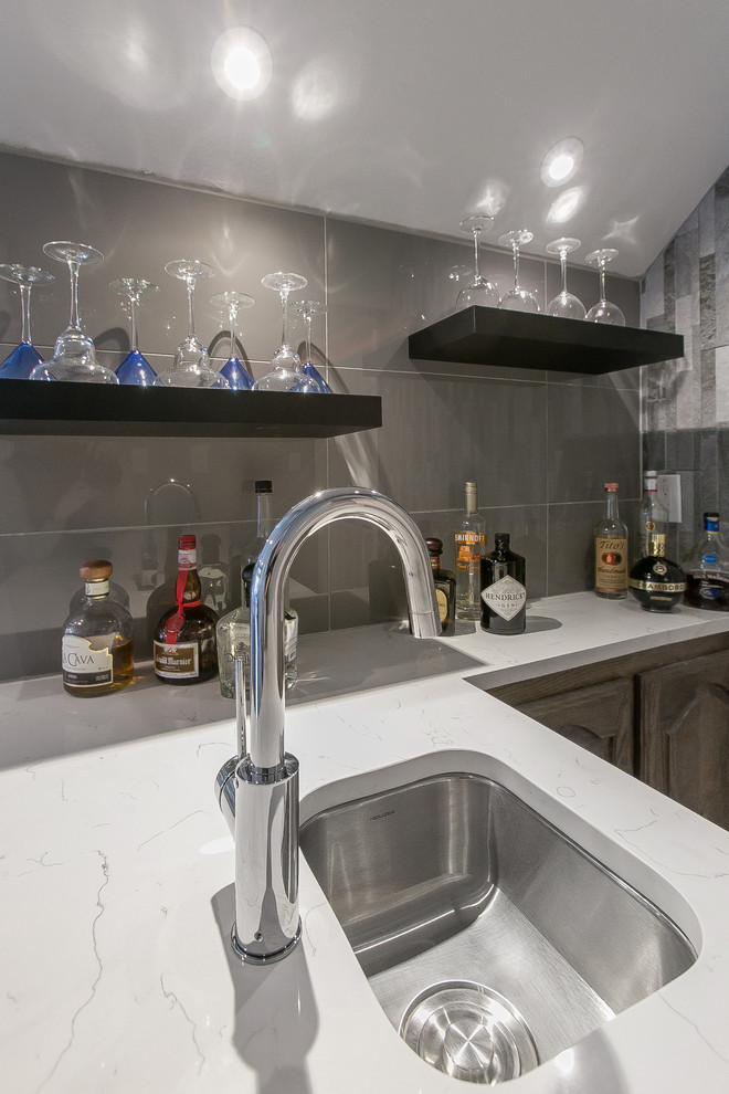This is an example of a small contemporary single-wall wet bar in Dallas with an undermount sink, quartz benchtops, grey splashback, stone tile splashback and white benchtop.