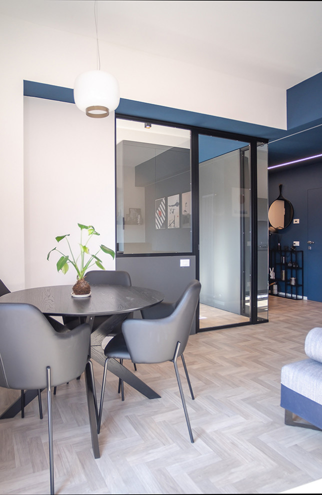 Modelo de salón abierto actual de tamaño medio con paredes azules, suelo de madera clara y suelo gris
