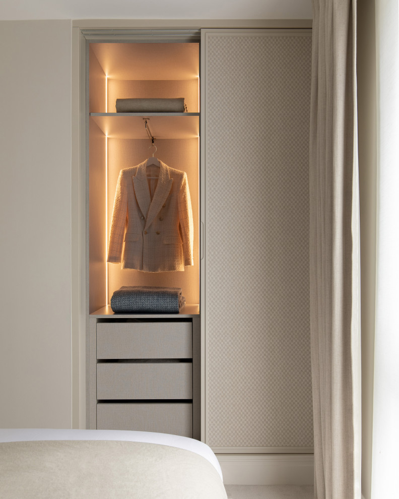 Ejemplo de vestidor unisex actual de tamaño medio con armarios estilo shaker, puertas de armario beige y moqueta