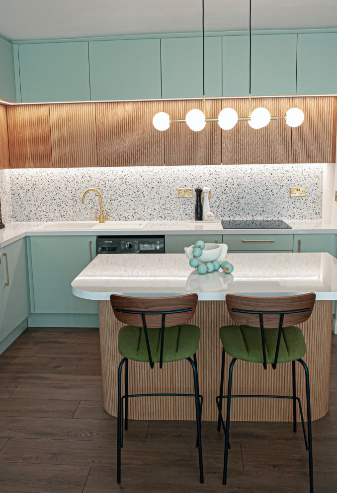 Mid-sized midcentury l-shaped eat-in kitchen in Dublin with flat-panel cabinets, light wood cabinets, multi-coloured splashback, black appliances, laminate floors, brown floor and white benchtop.