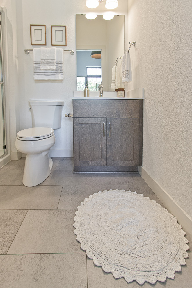 Idéer för ett klassiskt badrum, med luckor med infälld panel, en hörndusch, en toalettstol med separat cisternkåpa, vita väggar, klinkergolv i porslin, ett undermonterad handfat, grått golv och dusch med gångjärnsdörr