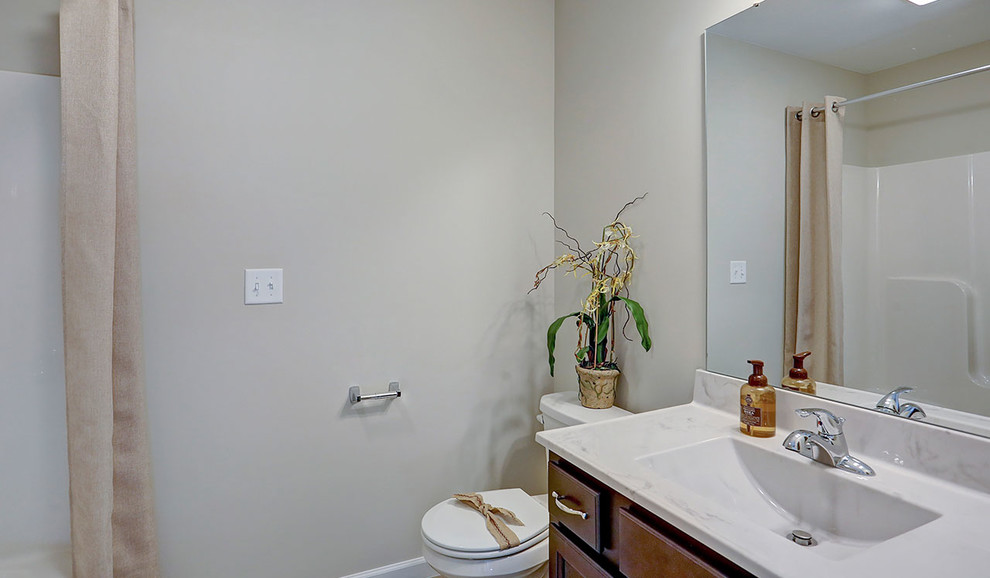 Large traditional kids bathroom in Other with dark wood cabinets, a shower/bathtub combo, a two-piece toilet, grey walls, an integrated sink and a shower curtain.