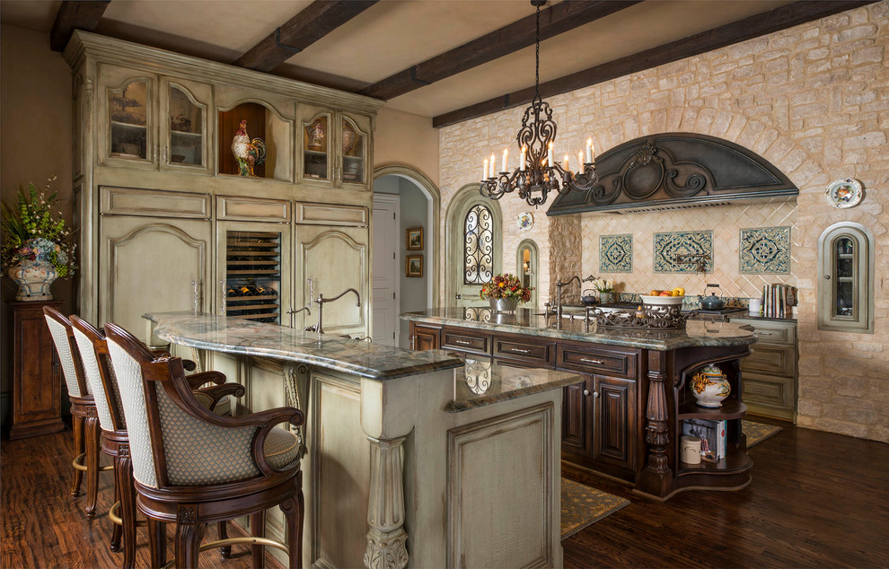 Photo of a mediterranean kitchen in Dallas with glass-front cabinets, beige splashback, panelled appliances, dark hardwood floors and multiple islands.
