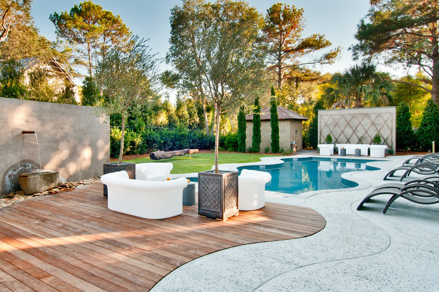 This is an example of a mid-sized eclectic courtyard custom-shaped pool in Charleston with decking.
