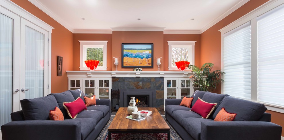 Photo of a contemporary living room in San Francisco with orange walls, a standard fireplace and a stone fireplace surround.