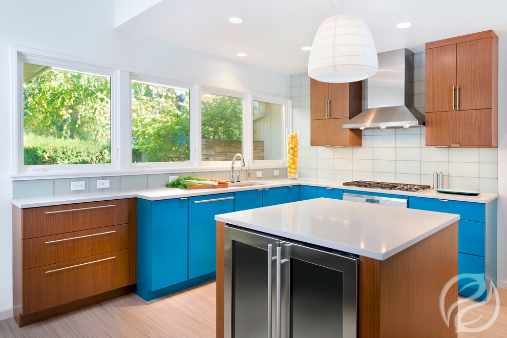 Example of an eclectic u-shaped light wood floor kitchen design in Milwaukee with flat-panel cabinets, turquoise cabinets, stainless steel appliances, an island and white countertops