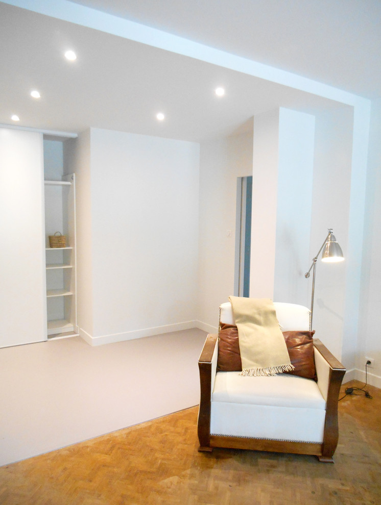Cette photo montre un salon moderne de taille moyenne et ouvert avec un mur blanc, sol en béton ciré, aucune cheminée, un téléviseur fixé au mur et un sol gris.