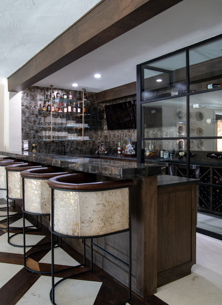 Large transitional seated home bar in Dallas with recessed-panel cabinets, dark wood cabinets, glass tile splashback, limestone floors, multi-coloured floor, marble benchtops and multi-coloured benchtop.