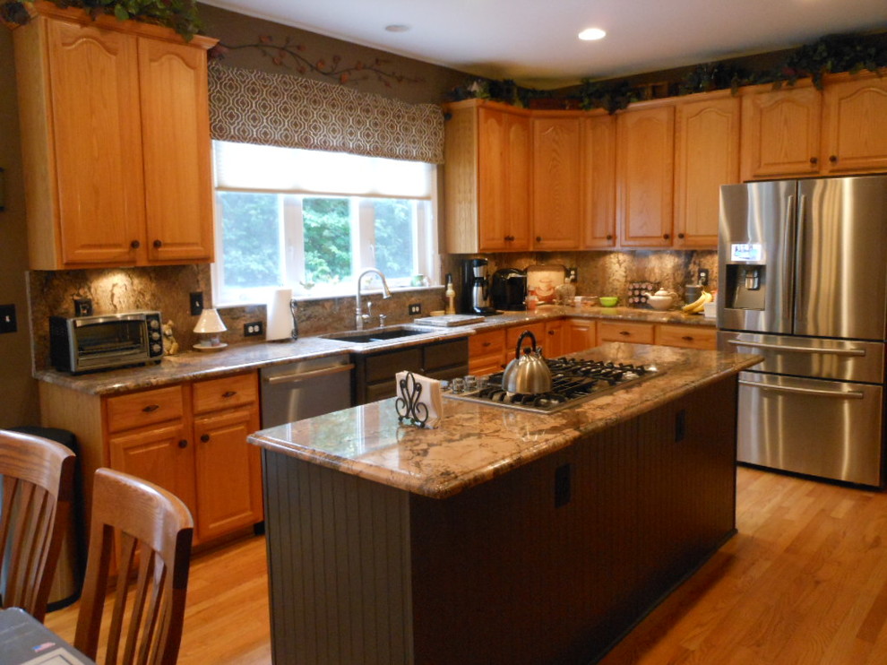 Inspiration for a mid-sized transitional u-shaped light wood floor enclosed kitchen remodel in DC Metro with an undermount sink, raised-panel cabinets, light wood cabinets, granite countertops, multicolored backsplash, stone slab backsplash, stainless steel appliances and an island
