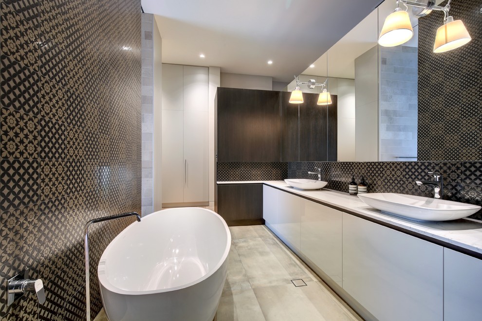Photo of a contemporary master bathroom in Adelaide with flat-panel cabinets, white cabinets, a freestanding tub, black tile, brown tile, multi-coloured walls, concrete floors, a vessel sink, beige floor, white benchtops, ceramic tile and engineered quartz benchtops.