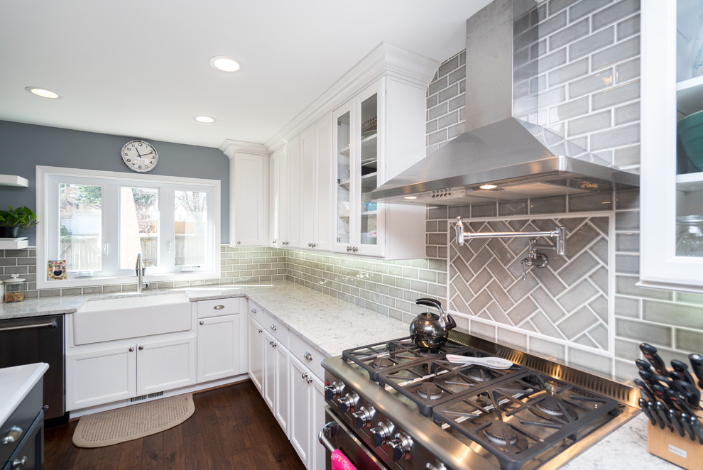 Example of a large transitional l-shaped dark wood floor and brown floor eat-in kitchen design in DC Metro with a farmhouse sink, shaker cabinets, white cabinets, quartz countertops, gray backsplash, porcelain backsplash, stainless steel appliances and an island
