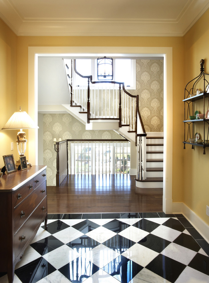 Inspiration for a traditional entryway in Chicago with yellow walls, dark hardwood floors and multi-coloured floor.