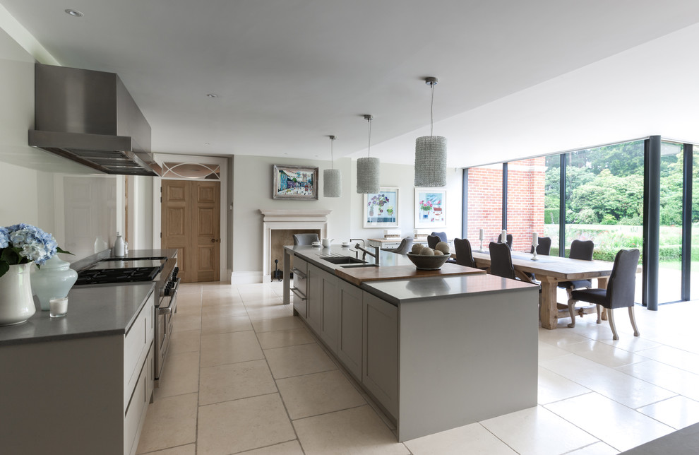 Design ideas for a large transitional galley eat-in kitchen in London with shaker cabinets, grey cabinets, grey splashback and glass sheet splashback.
