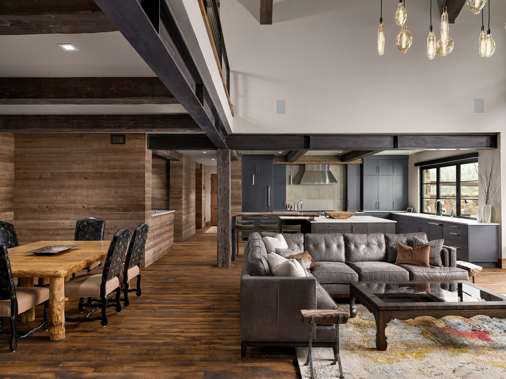 Inspiration for a large rustic open concept dark wood floor family room remodel in Denver with a standard fireplace, a stone fireplace and a wall-mounted tv