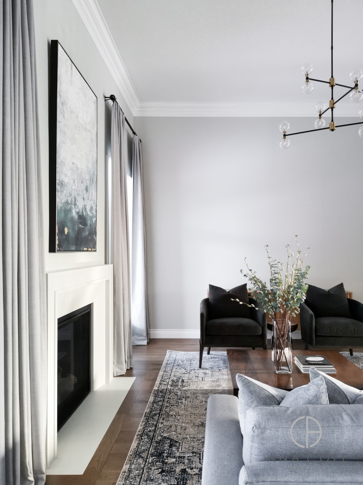 This is an example of a large enclosed family room in Toronto with grey walls, light hardwood floors, a ribbon fireplace, a plaster fireplace surround, a wall-mounted tv and brown floor.