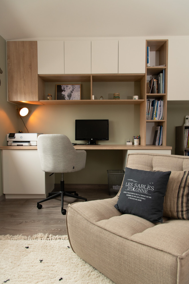 Foto di un piccolo ufficio minimalista con pareti verdi, pavimento in laminato, scrivania incassata e pavimento marrone