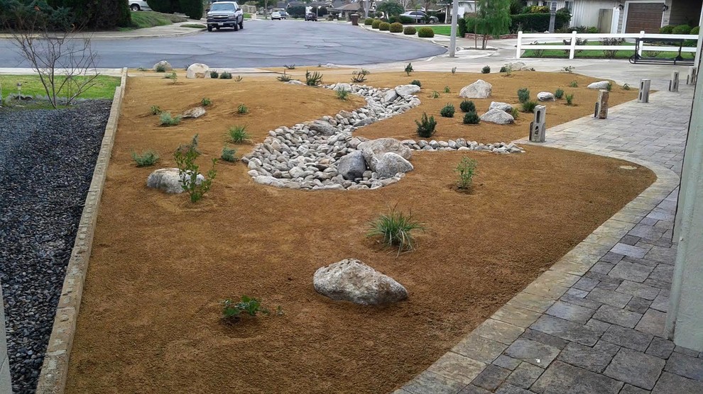 Photo of a mid-sized front yard full sun xeriscape for summer in Orange County with brick pavers.