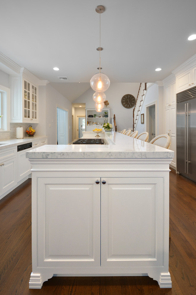 Kitchen pantry - mid-sized transitional galley medium tone wood floor kitchen pantry idea in New York with a farmhouse sink, white cabinets, white backsplash, stainless steel appliances and an island