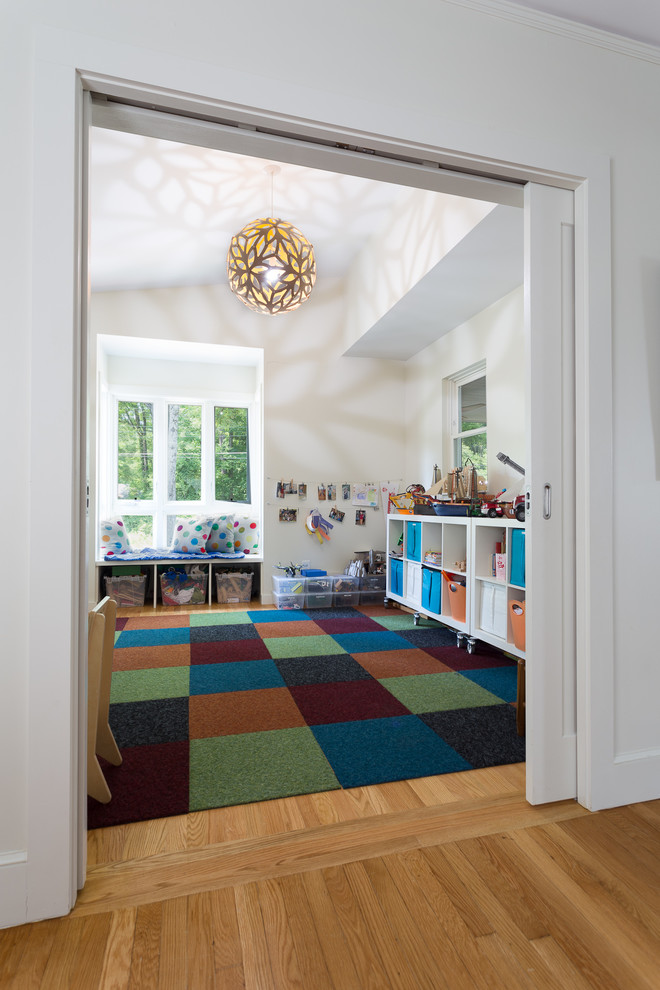 Mid-sized contemporary gender-neutral kids' room in Raleigh with white walls and light hardwood floors.