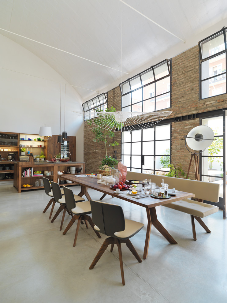 Expansive industrial open plan dining in Hanover with white walls, concrete floors, no fireplace and grey floor.