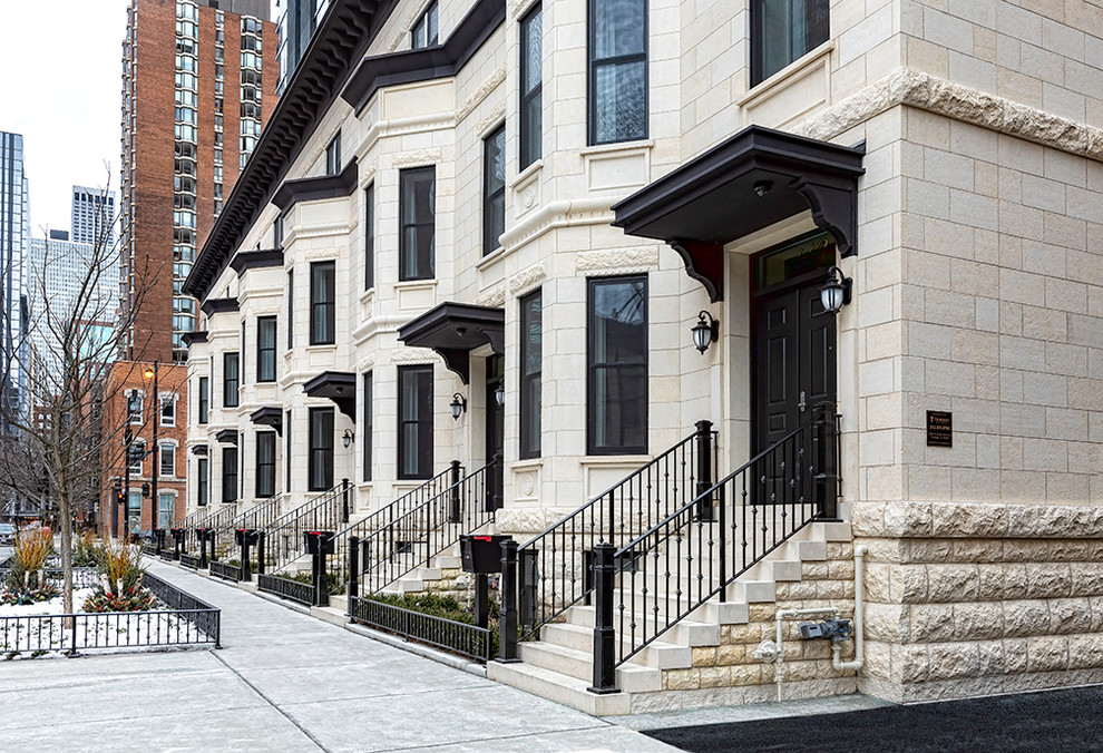 Large traditional three-storey white townhouse exterior in Chicago with stone veneer and a flat roof.