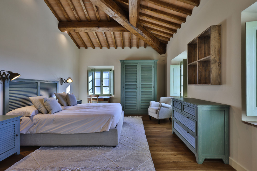 Large country master painted wood floor, brown floor and exposed beam bedroom photo in Florence with yellow walls