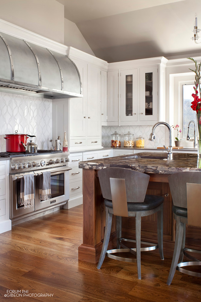 Inspiration for a transitional u-shaped eat-in kitchen remodel in Denver with an undermount sink, recessed-panel cabinets, white cabinets, solid surface countertops, metallic backsplash, mosaic tile backsplash and stainless steel appliances