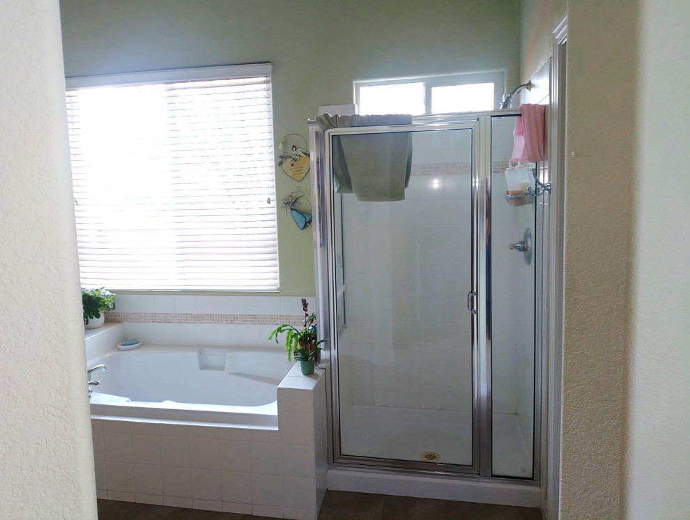 Corner shower - large transitional master gray tile and porcelain tile vinyl floor, beige floor and double-sink corner shower idea with shaker cabinets, medium tone wood cabinets, a two-piece toilet, green walls, an undermount sink, quartzite countertops, a hinged shower door, beige countertops and a built-in vanity