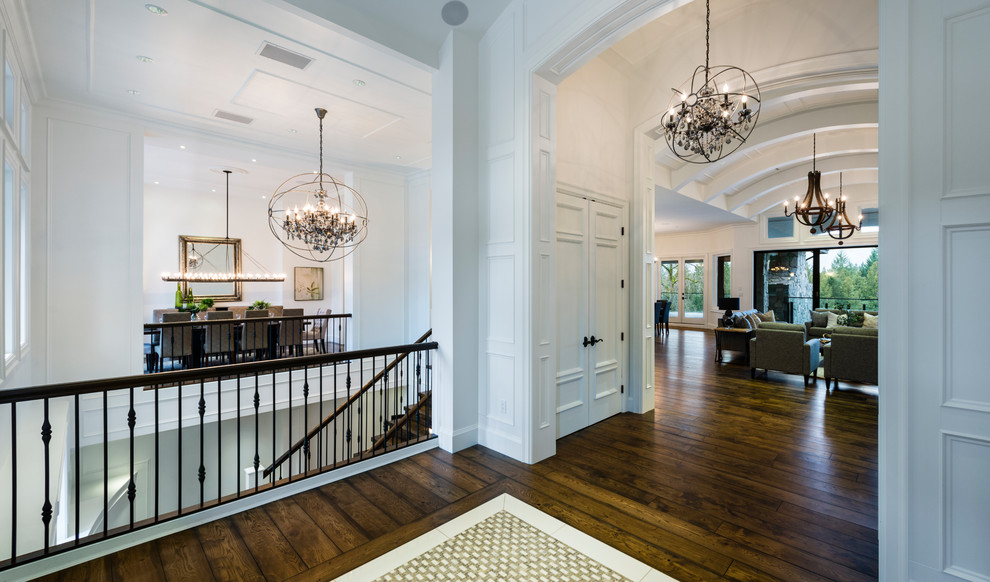 Foyer - huge rustic medium tone wood floor and brown floor foyer idea in Vancouver with white walls and a dark wood front door