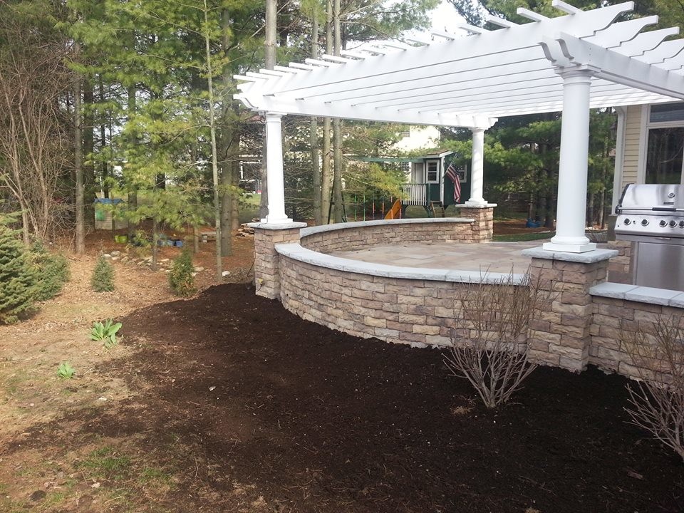Inspiration for a large traditional backyard patio in Milwaukee with an outdoor kitchen, natural stone pavers and a pergola.