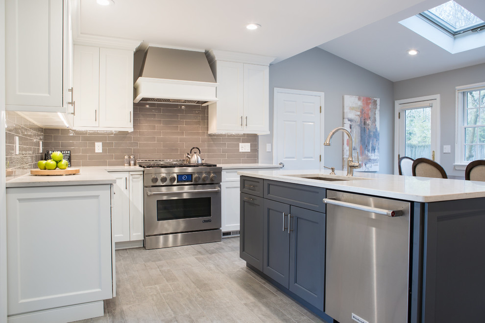 Example of a large transitional ceramic tile open concept kitchen design in New York with an undermount sink, shaker cabinets, white cabinets, quartz countertops, gray backsplash, ceramic backsplash, stainless steel appliances and an island