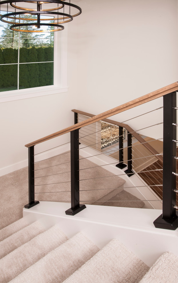 Cette photo montre un escalier moderne en U de taille moyenne avec des marches en moquette, des contremarches en moquette et un garde-corps en câble.