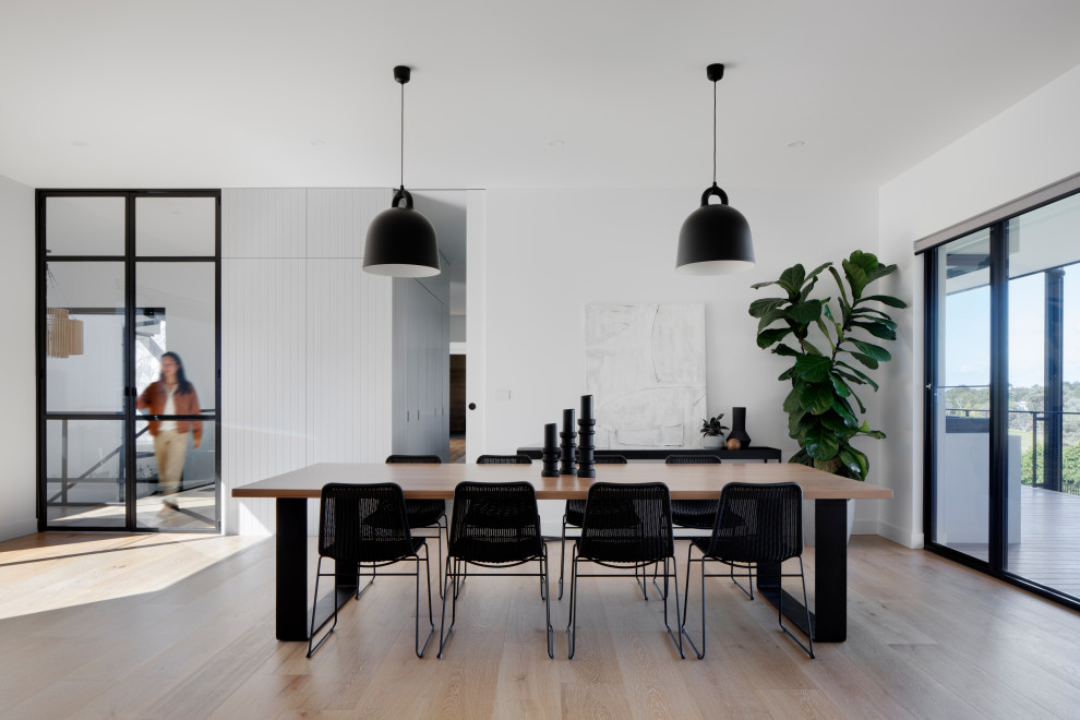 Inspiration for an expansive contemporary kitchen/dining combo in Melbourne with white walls, light hardwood floors and brown floor.