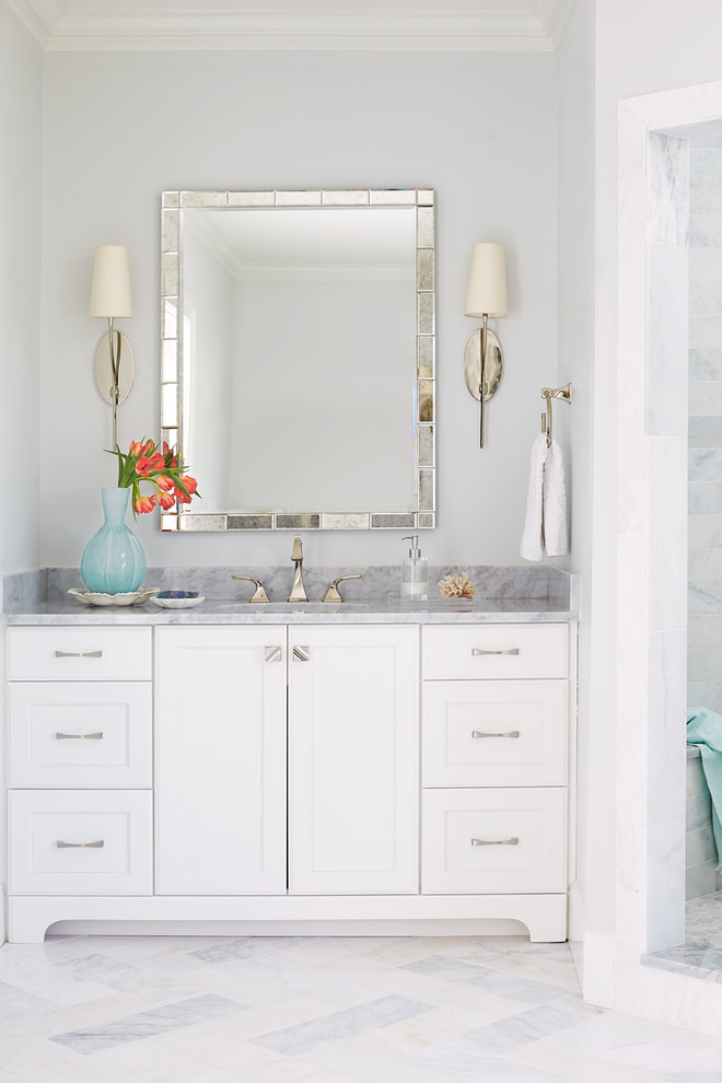 Photo of a large transitional master bathroom in Raleigh with shaker cabinets, white cabinets, a freestanding tub, a corner shower, a one-piece toilet, gray tile, marble, grey walls, marble floors, an undermount sink, marble benchtops, grey floor and a hinged shower door.