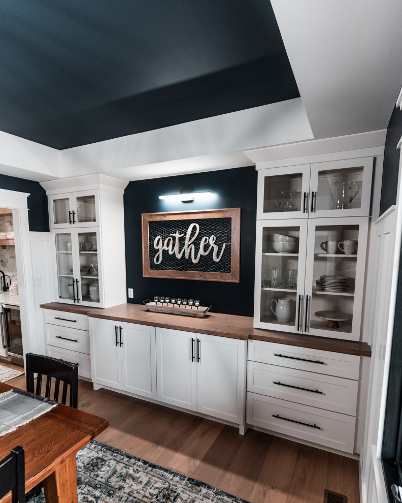 This is an example of a large country separate dining room in Other with blue walls, light hardwood floors, recessed and decorative wall panelling.