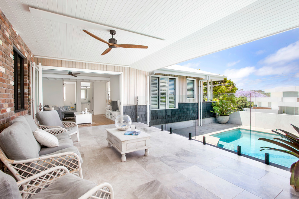 Inspiration for a beach style backyard patio in Central Coast with tile and a roof extension.